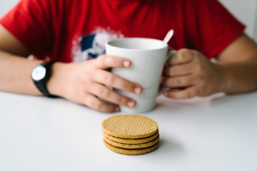 Close up of boy having a breakfast with biscuits, focus on biscu