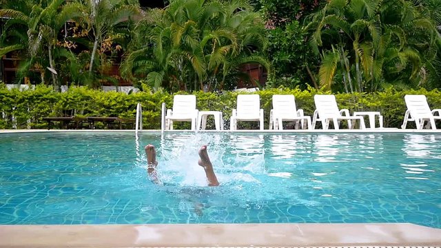 Young sexy woman in bikini jumping into infinity pool in lush palm tree jungle on tropical island. Girl enjoying summer vacation. slow motion. 1920x1080