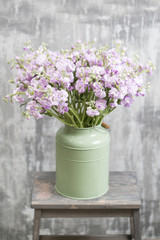 Bouquet of Beautiful lilac color gillyflower, levkoy or mattiola. Spring flowers in vase on wooden table. Vertical photo