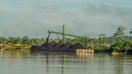 coal stockpile with conveyor load the barge on Mahakam riverbank, Borneo, Indonesia