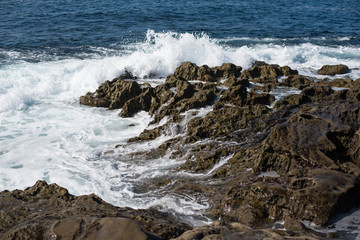 Small wave crashing against the rocks.