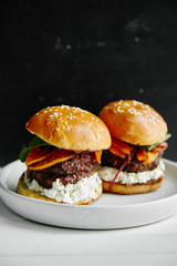Burgers with grilled beef patties, cream cheese and spinach on classical bun.