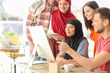 Office employees and their Muslim coworkers having business meeting in office