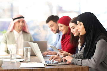 Fototapeta na wymiar Office employees and their Muslim coworkers having business meeting in office