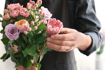Male florist holding beautiful bouquet, closeup