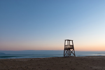 A lifeguard tower on the mediterranean beach at sunset