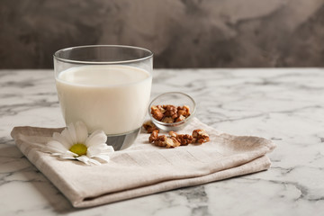 Glass with milk and nuts on table
