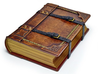 Aged leather book with straps and gilded paper edges - laying on the table isolated