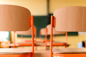Empty classroom with school desks, chairs and blackboard. Education concept.
