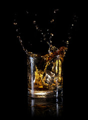 Splash in round glass of whiskey
