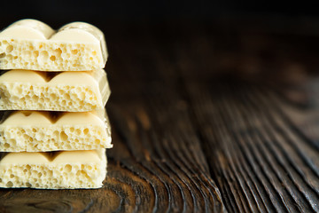 pyramid of white porous chocolate on a wooden vintage old background