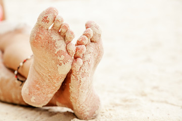 women's feet in the sand, beach rest and relax concept