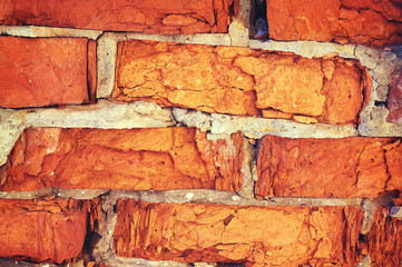 A wall of cracked red brick from the bad weather.