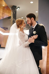Naklejka premium Wedding couple hugging and kissing, the first day of life together. Bride and groom after wedding ceremony, beautiful couple loves each other and hugging