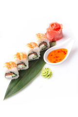 Seductive set of sushi rolls with shrimp and cream cheese laid out on a banana leaf.