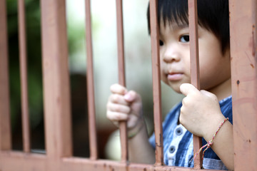 Obraz premium Hand of kid on the steel fence door