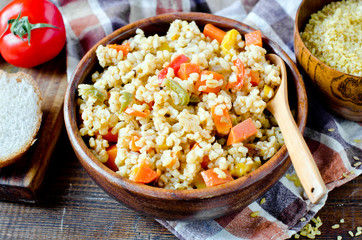 Porridge from bulgur with vegetables: carrots, bell peppers, onions, zucchini