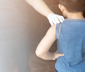 Fototapeta na wymiar Doctor preparing an injection in the arm boy