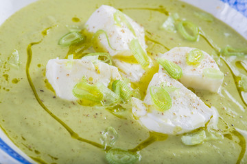 Crema o sopa de calabacín con manzana y cebolleta y queso mozzarella aderezada con aceite de oliva virgen extra para una dieta vegetariana y saludable