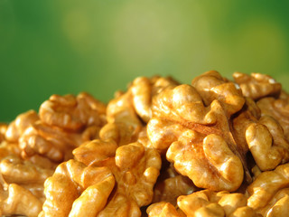 Fototapeta premium Walnut kernels on green natural background with free copy space