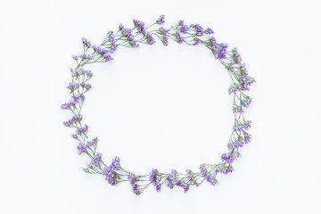Flower wreath frame made of different flowers and leaves, flat lay, top view. Holiday background