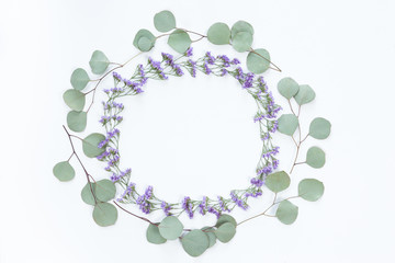 Flower wreath frame made of different flowers and leaves, flat lay, top view. Holiday background