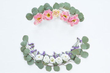 Flower wreath frame made of different flowers and leaves, flat lay, top view. Holiday background