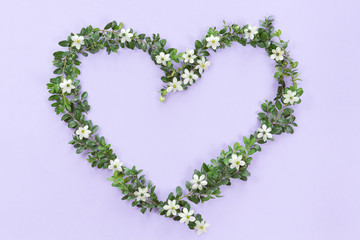 Top view of heart symbol made of natural flowers, buds and leaves. Love concept, flat lay.