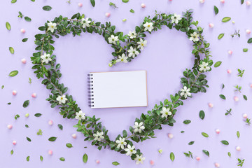 Top view of heart symbol made of natural flowers, buds and leaves. Love concept, flat lay.