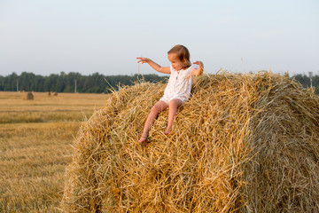 Naklejka na ściany i meble Little girl walking in the grain fields