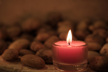 Prayer and hope concept. Retro pink candle light and old stone with lighting effect and glitter abstract background with bokeh defocused lights
