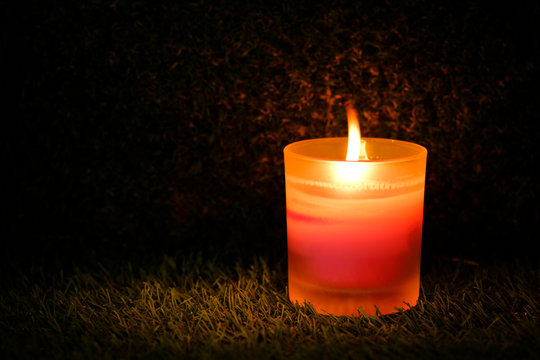 Prayer and hope concept. Retro pink candle light in crystal glass