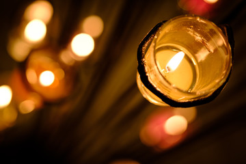 Prayer and hope concept. Retro pink candle light in crystal glass and old wooden