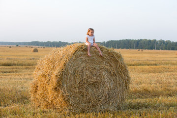 Naklejka na ściany i meble Little girl walking in the grain fields