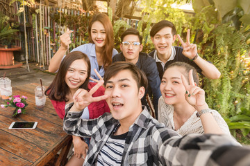 Group of six teenagers taking selfie with fun together in afternoon