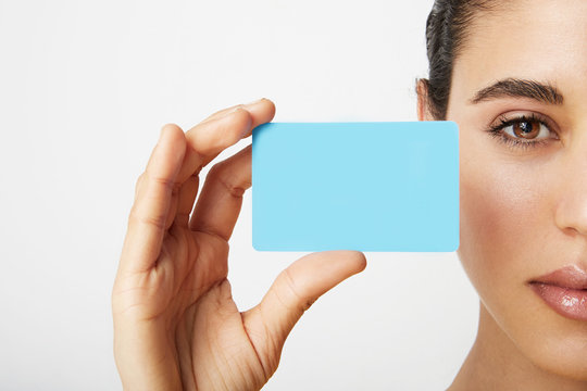 Woman holding card, blank card, mock up, background with copy space, for advertising.