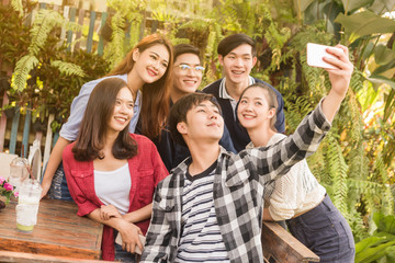 Group of six teenagers taking selfie with fun together in afternoon
