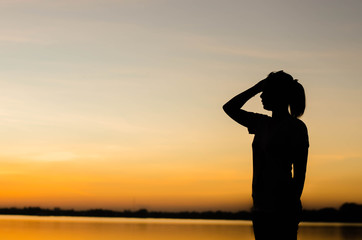 Fototapeta premium The silhouette of a woman standing looking forward with hope.