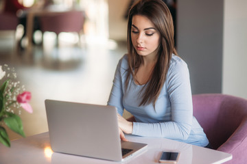 Fototapeta na wymiar brunette woman working on her laptop at a restaurant
