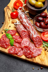 Dried organic salami sausage on wooden cutting board