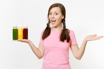 Fun woman holds row of green, red, yellow detox smoothies in bottles isolated on white background. Proper nutrition, vegetarian drink, healthy lifestyle, dieting concept. Copy space for advertisement.