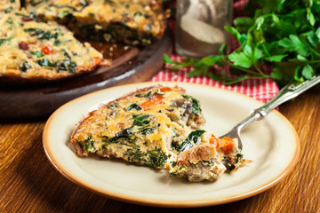 Portion of frittata made of eggs, mushrooms and spinach