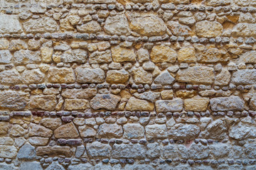 Background of pattern of yellow and gray decorative grunge weathered uneven stone wall surface