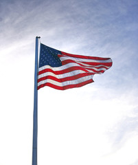 American flag in front of a dramatic sky with dark clouds