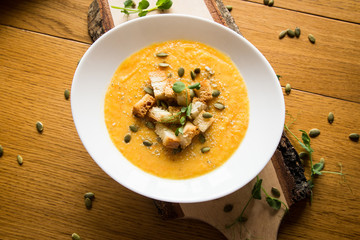 Wood board with orange pumkin soup