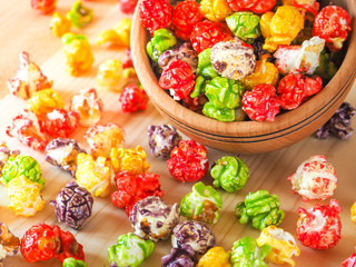 Multi-colored popcorn on a wooden table.
