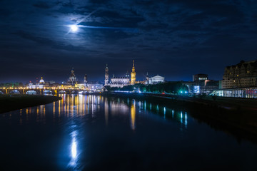 Panorama of the German city Dresden at night with the Elbe and reflecting lights