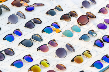 Display of colorful sunglasses for sale in a street, summer and sun fashion and lifestyle accessory