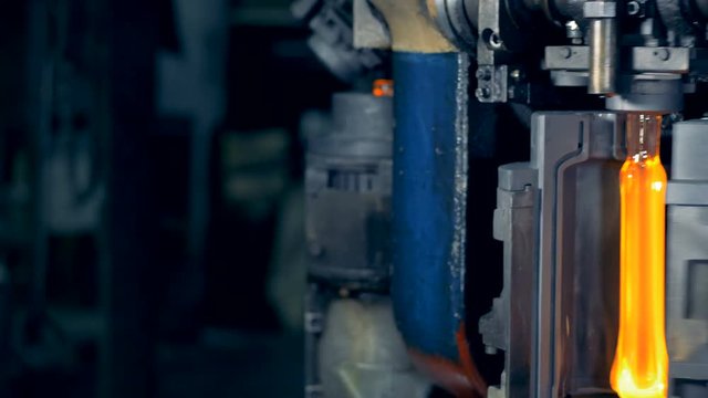 Semi-finished heated bottles are getting transformed by a factory machine