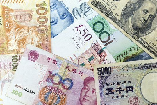 Currency banknotes spread across frame including world major currencies